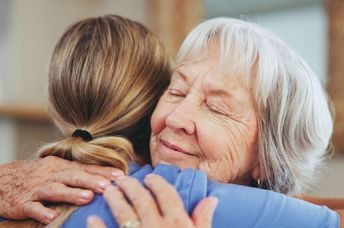 A woman hugs another woman.