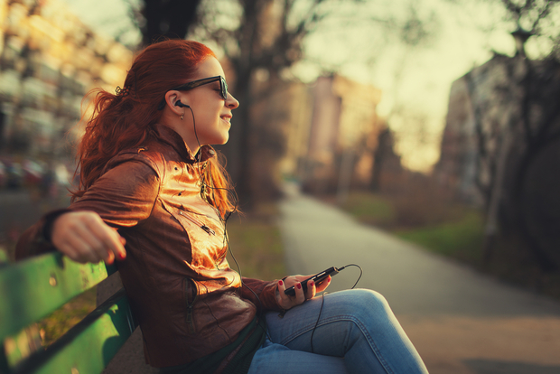 Woman listens to music on smartphone Woman listens to music on smartphone