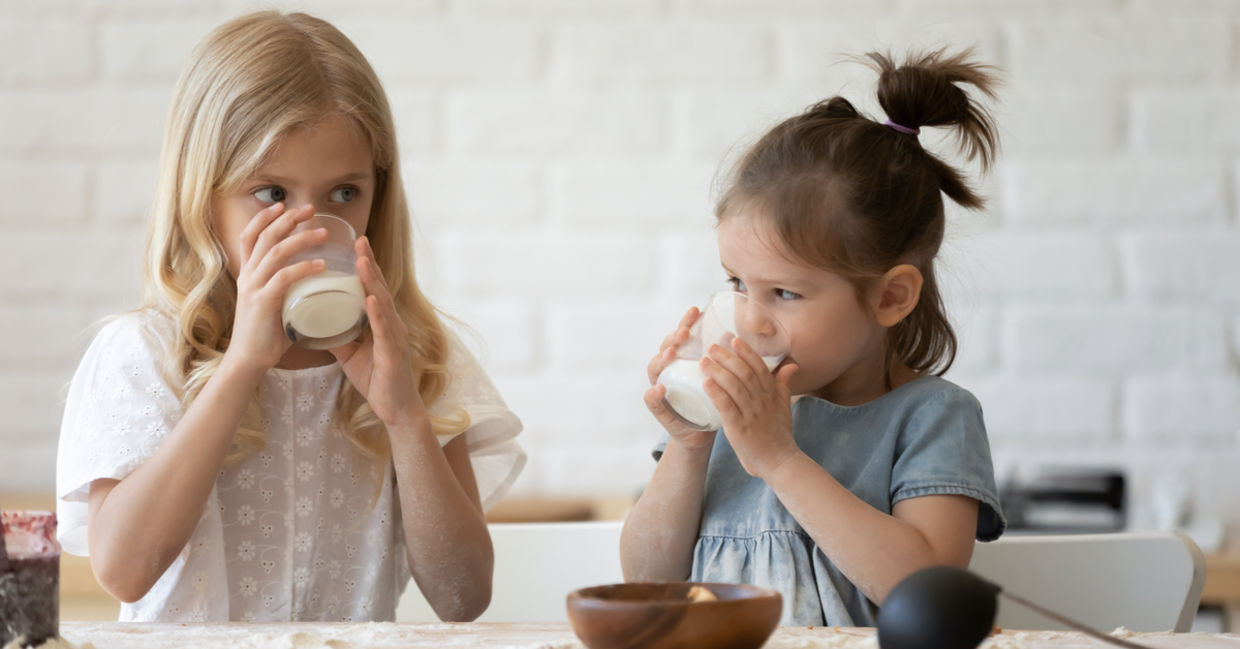 Smiling little sisters drinking milk Smiling little sisters drinking milk