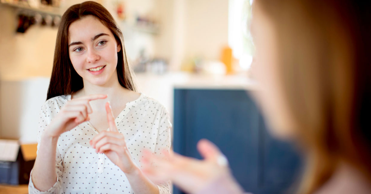 Two teenage girls having a conversation using sign language Two teenage girls having a conversation using sign language