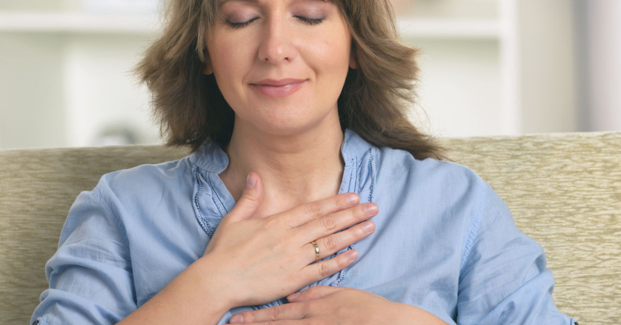 A woman practices self reiki to achieve a sense of inner harmony. A woman practices self reiki to achieve a sense of inner harmony.