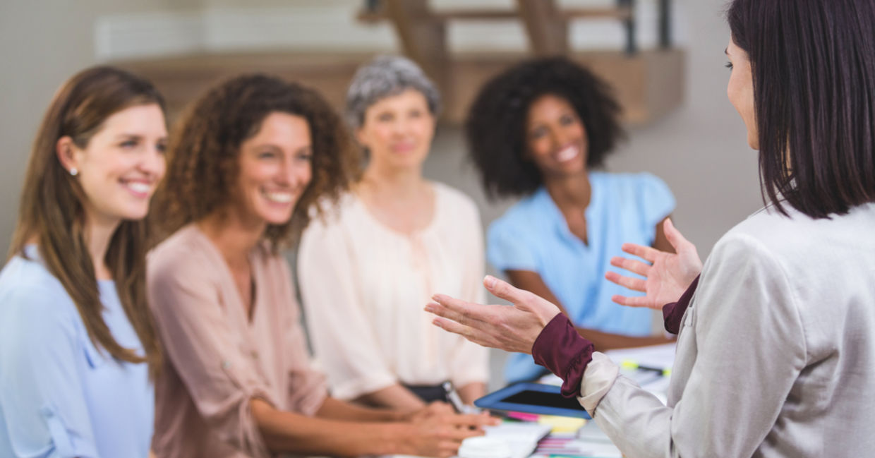Women presenting to her female colleagues at work. Women presenting to her female colleagues at work.