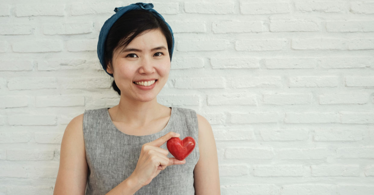 A kind woman holding a red heart. A kind woman holding a red heart.