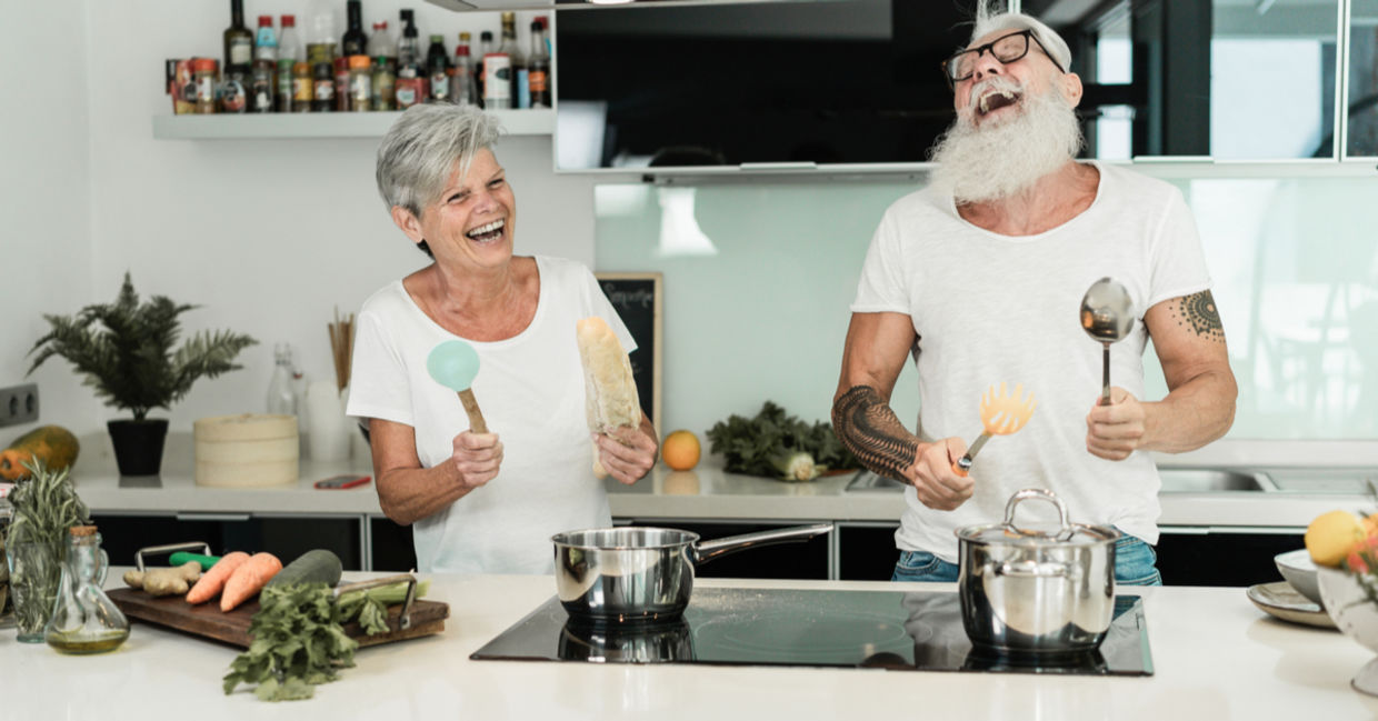 Senior couple dancing while cooking together. Senior couple dancing while cooking together.