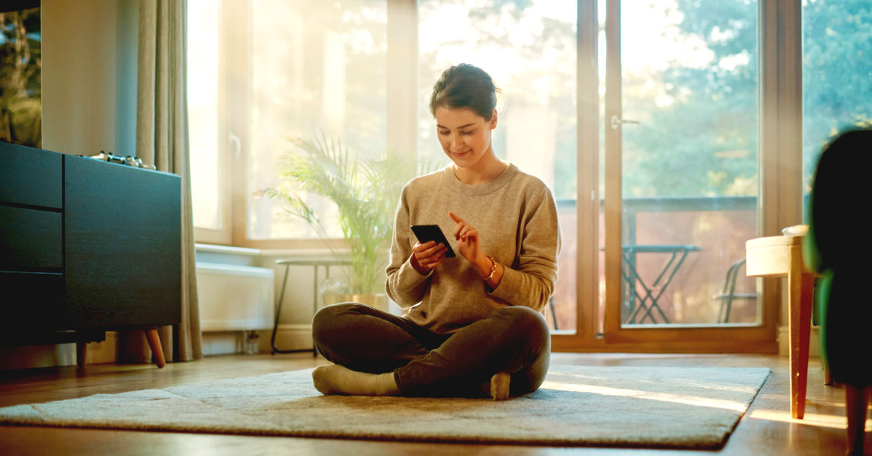 Smiling young woman using her phone to plan and be productive. Smiling young woman using her phone to plan and be productive.