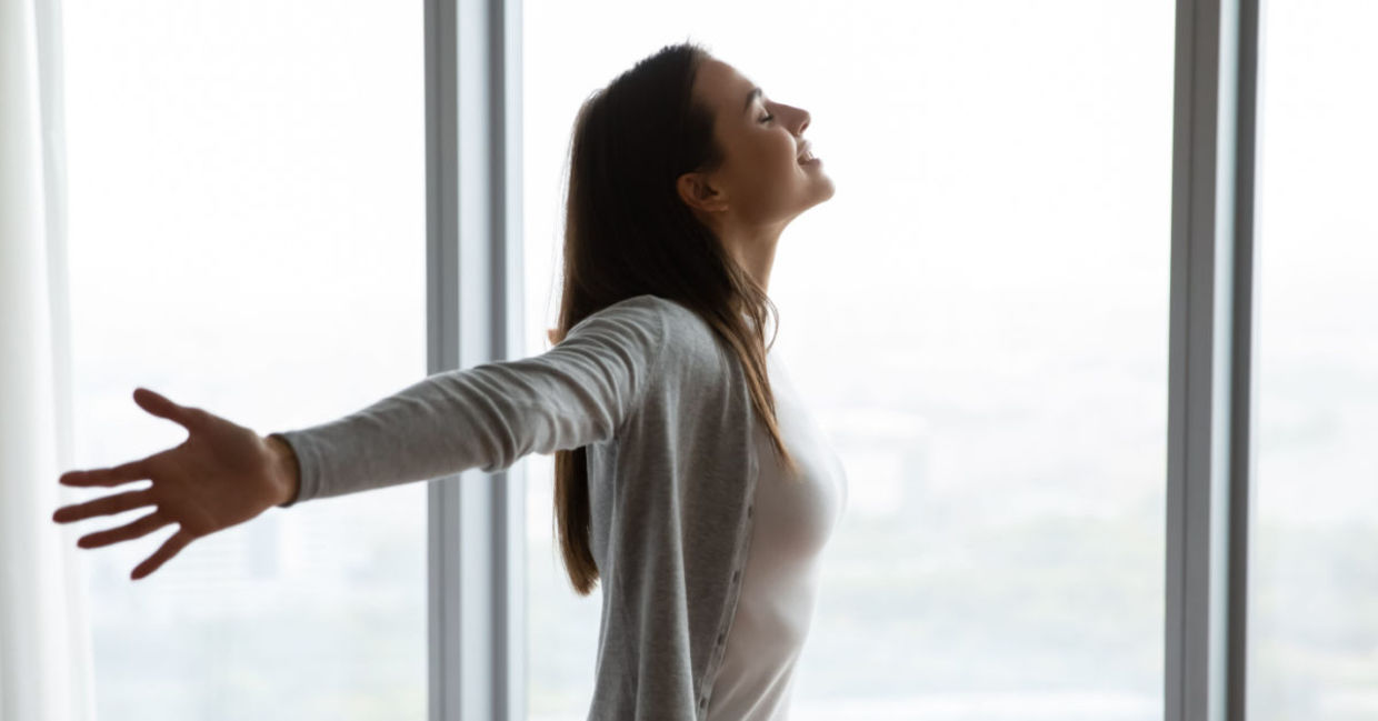 A woman embraces life, smiling with arms wide open. A woman embraces life, smiling with arms wide open.