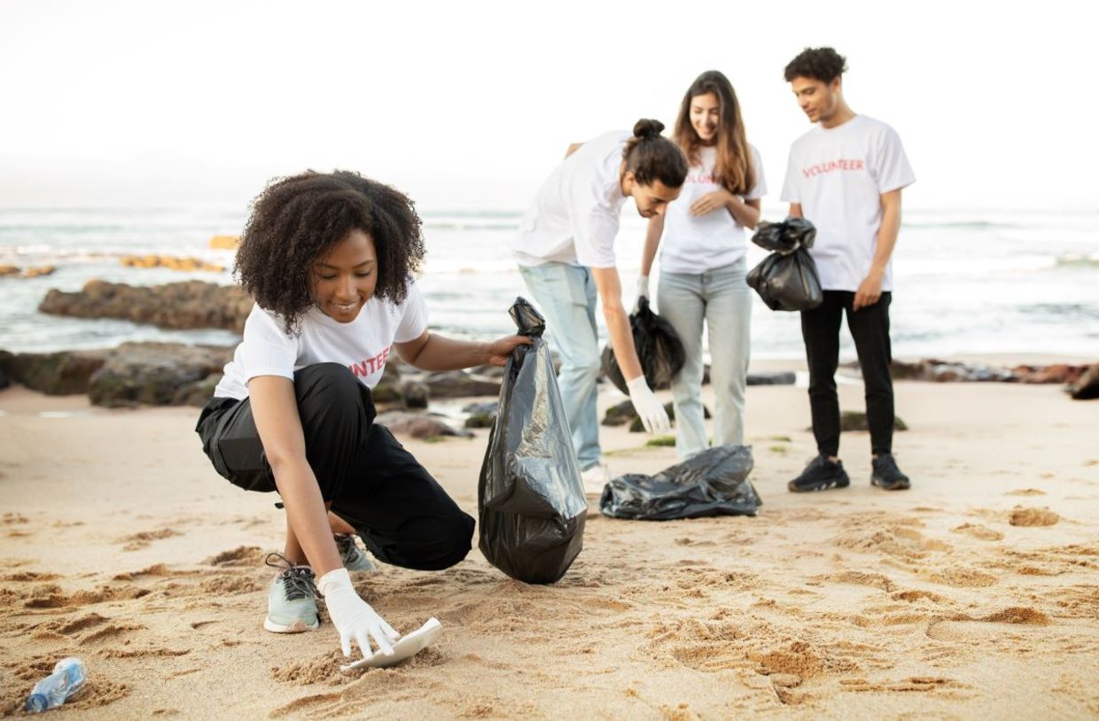 Young volunteers cleaning a beach. Young volunteers cleaning a beach.