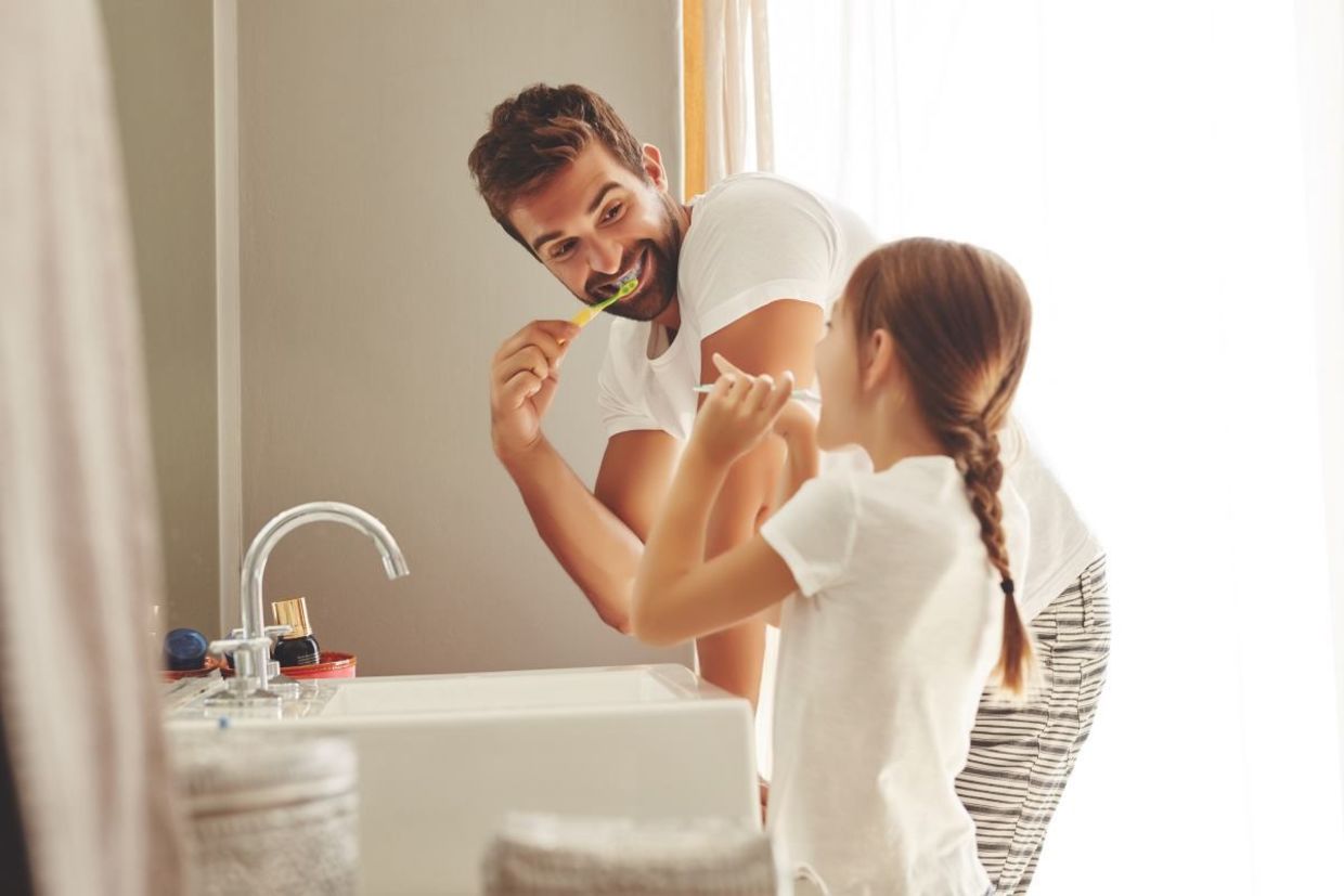 Father and daughter brushing their teeth. Father and daughter brushing their teeth.