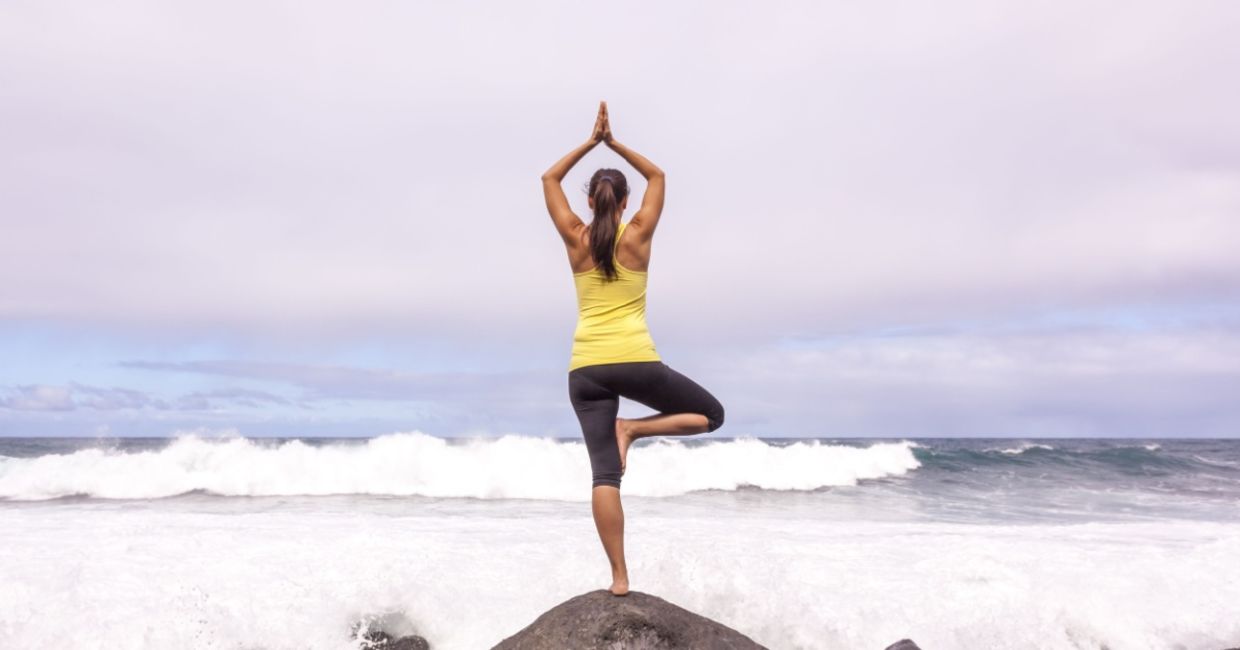 In the tree yoga pose at the beach. In the tree yoga pose at the beach.