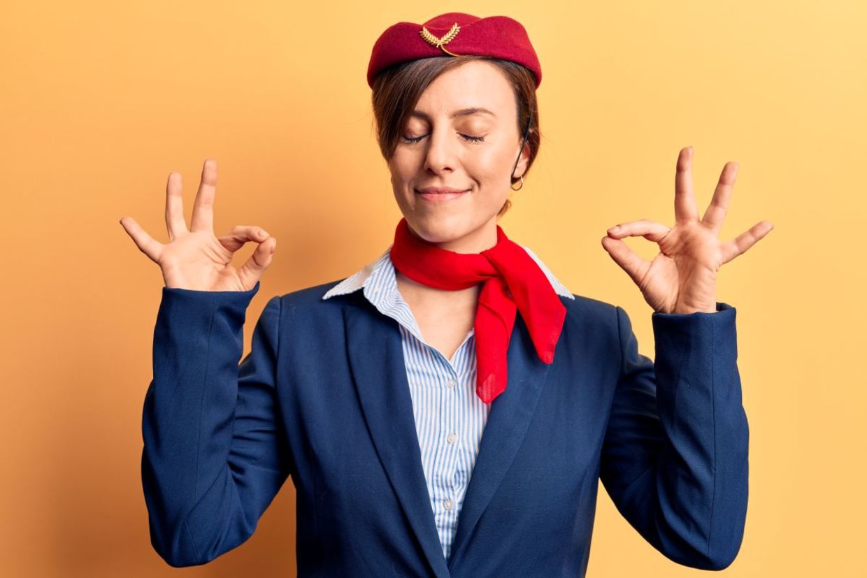 A flight attendant leading plane yoga. A flight attendant leading plane yoga.