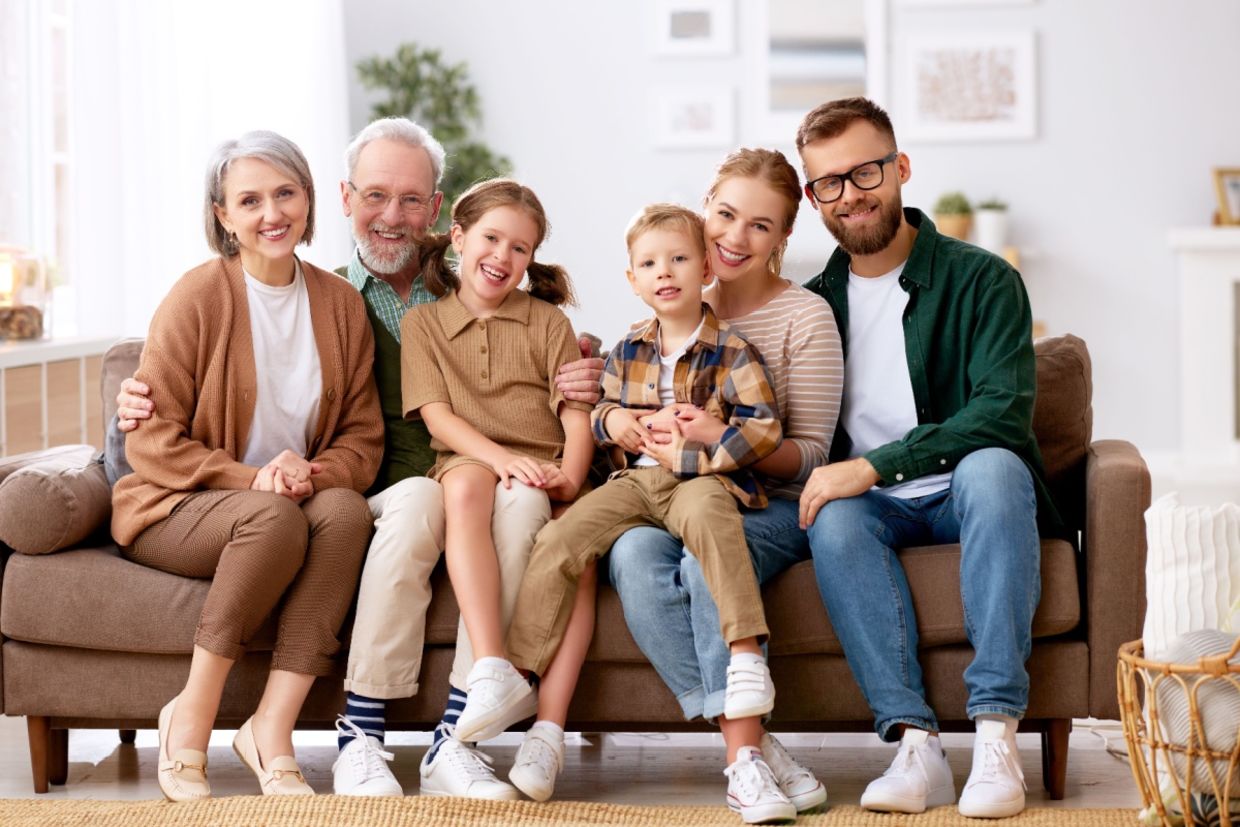 A family smiles while sitting on a couch. A family smiles while sitting on a couch.